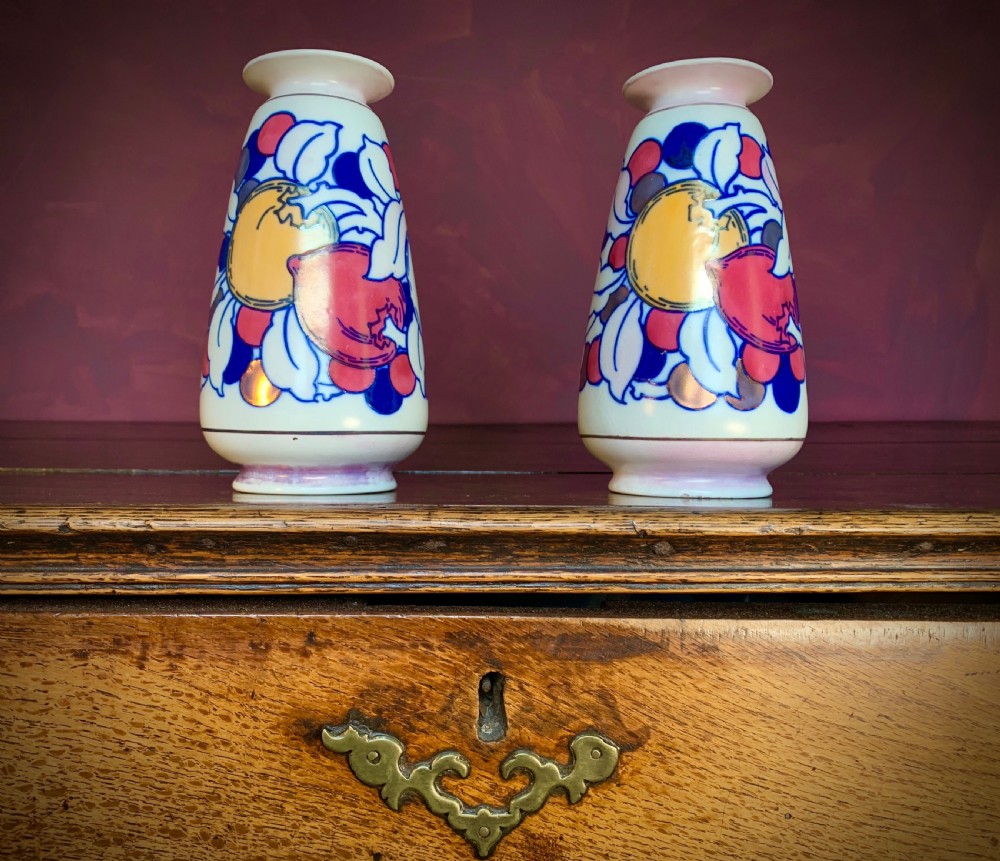 A pair of Art Deco earthenware vases featuring tubelined fruit motifs with iridescent lustre glazing on a cream background. View IV
