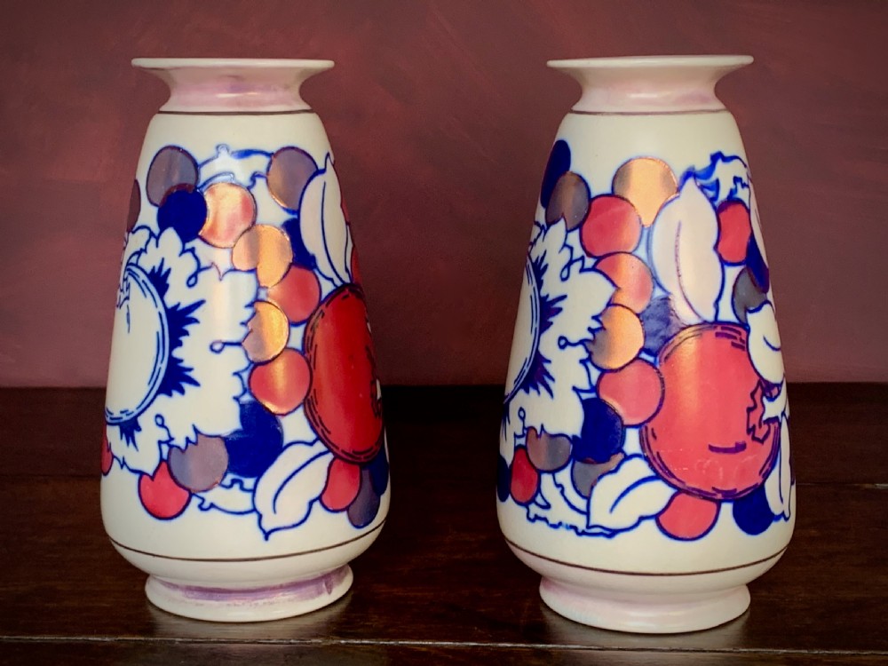 A pair of Art Deco earthenware vases featuring tubelined fruit motifs with iridescent lustre glazing on a cream background. View VIII