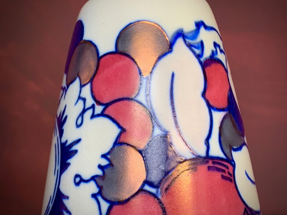 A pair of Art Deco earthenware vases featuring tubelined fruit motifs with iridescent lustre glazing on a cream background. View X