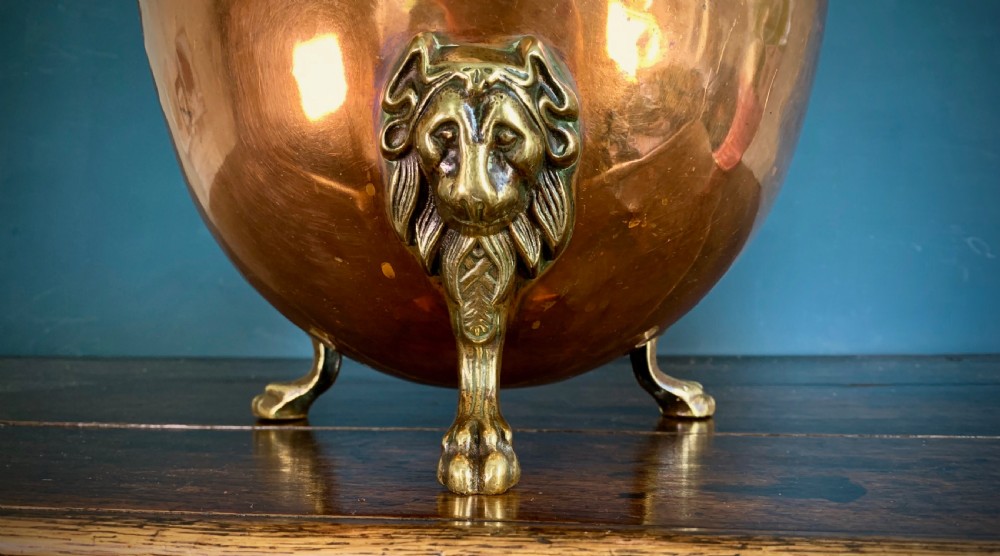 A rounded nineteenth-century copper jardiniere bowl supported on three cast brass lion mask paw feet. View IV