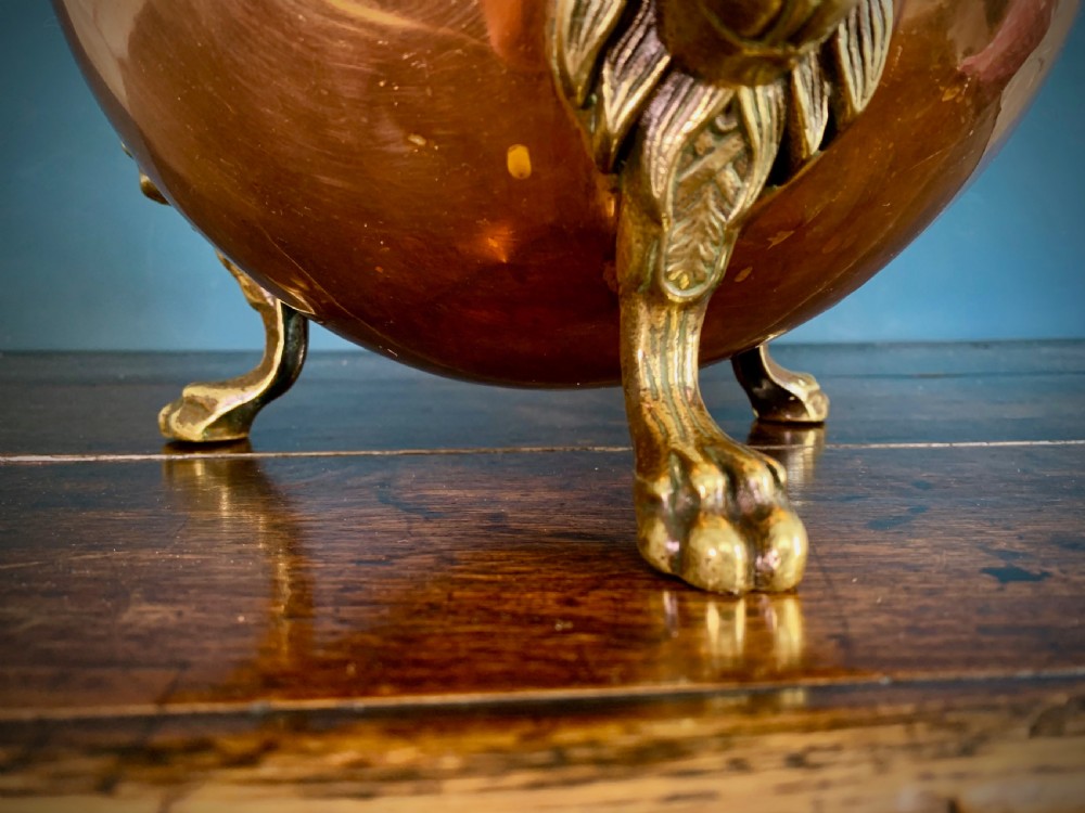 A rounded nineteenth-century copper jardiniere bowl supported on three cast brass lion mask paw feet. View V