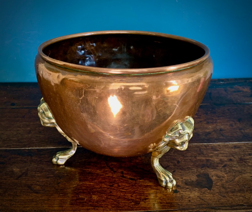 A rounded nineteenth-century copper jardiniere bowl supported on three cast brass lion mask paw feet. View IX
