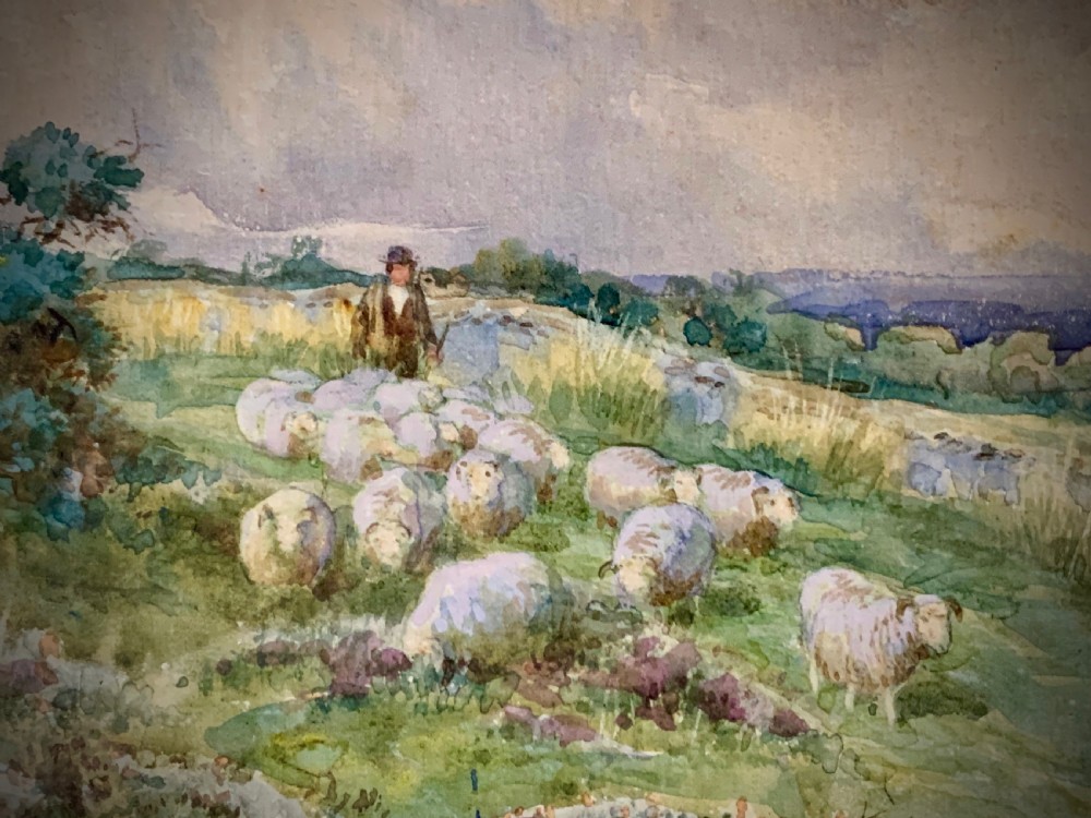 An antique framed watercolour painting depicting a shepherd driving sheep across a green moorland beneath a cloudy sky, set within a cream mount and gold frame. View III