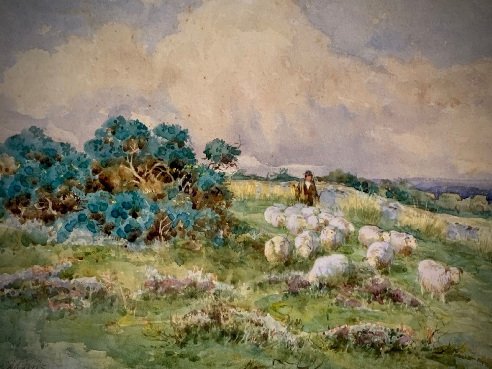 An antique framed watercolour painting depicting a shepherd driving sheep across a green moorland beneath a cloudy sky, set within a cream mount and gold frame. View VI