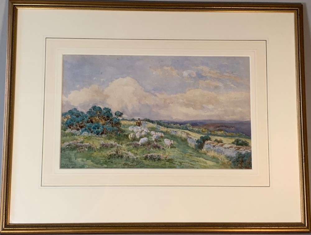 An antique framed watercolour painting depicting a shepherd driving sheep across a green moorland beneath a cloudy sky, set within a cream mount and gold frame. View IX