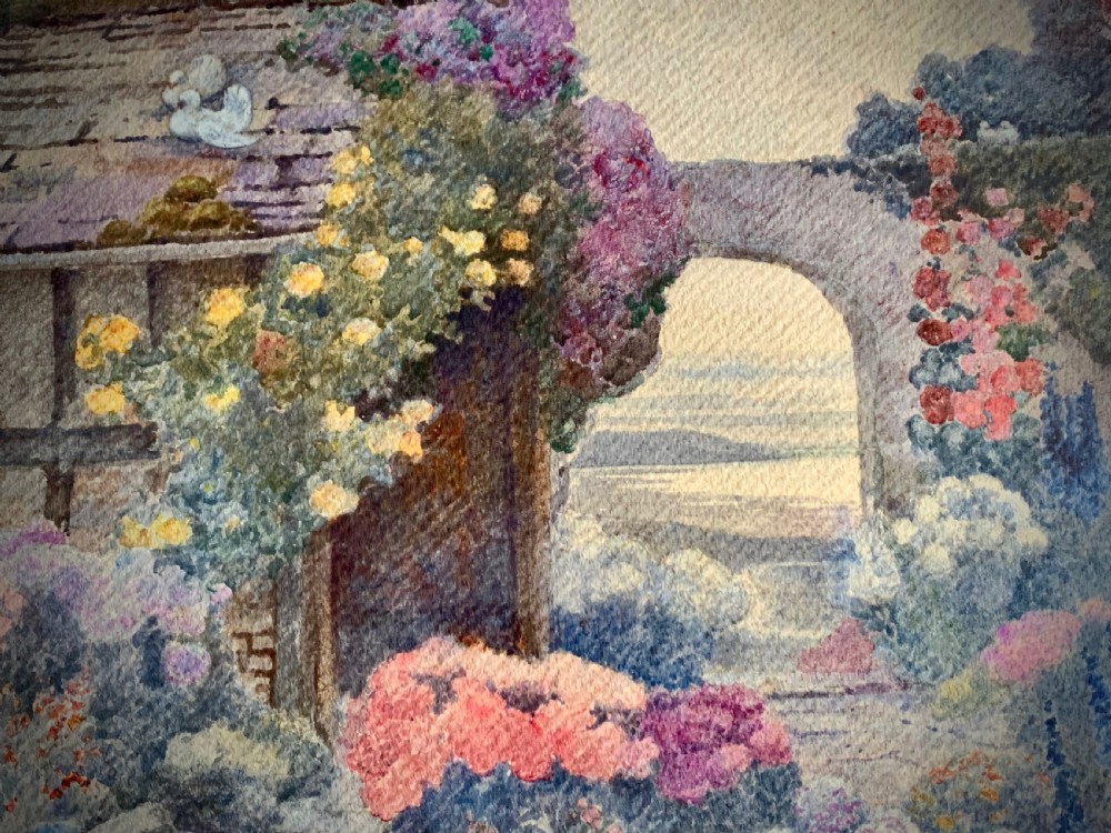 A framed 1928 watercolour painting depicting a stone path leading through a lush cottage garden towards a stone archway, presented in a wide gold frame. View IV
