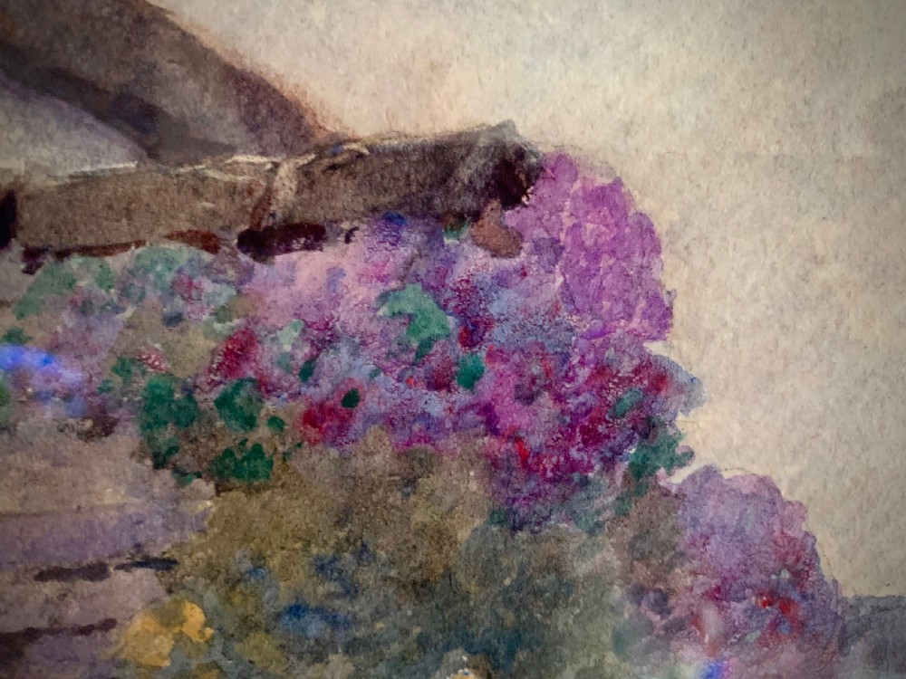 A framed 1928 watercolour painting depicting a stone path leading through a lush cottage garden towards a stone archway, presented in a wide gold frame. View V