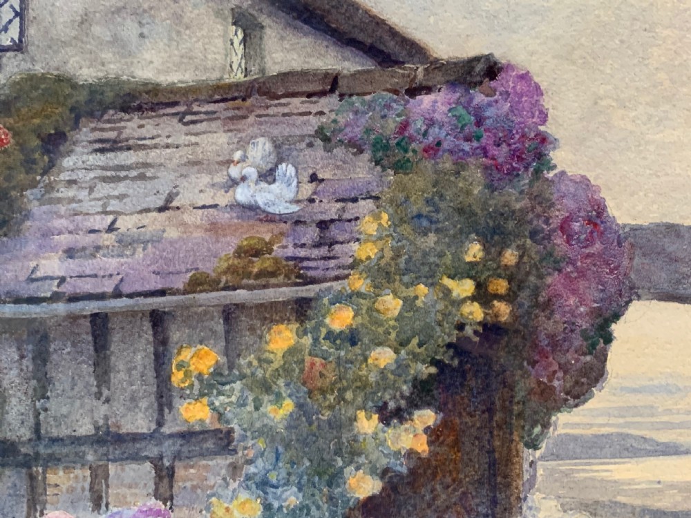 A framed 1928 watercolour painting depicting a stone path leading through a lush cottage garden towards a stone archway, presented in a wide gold frame. View IX