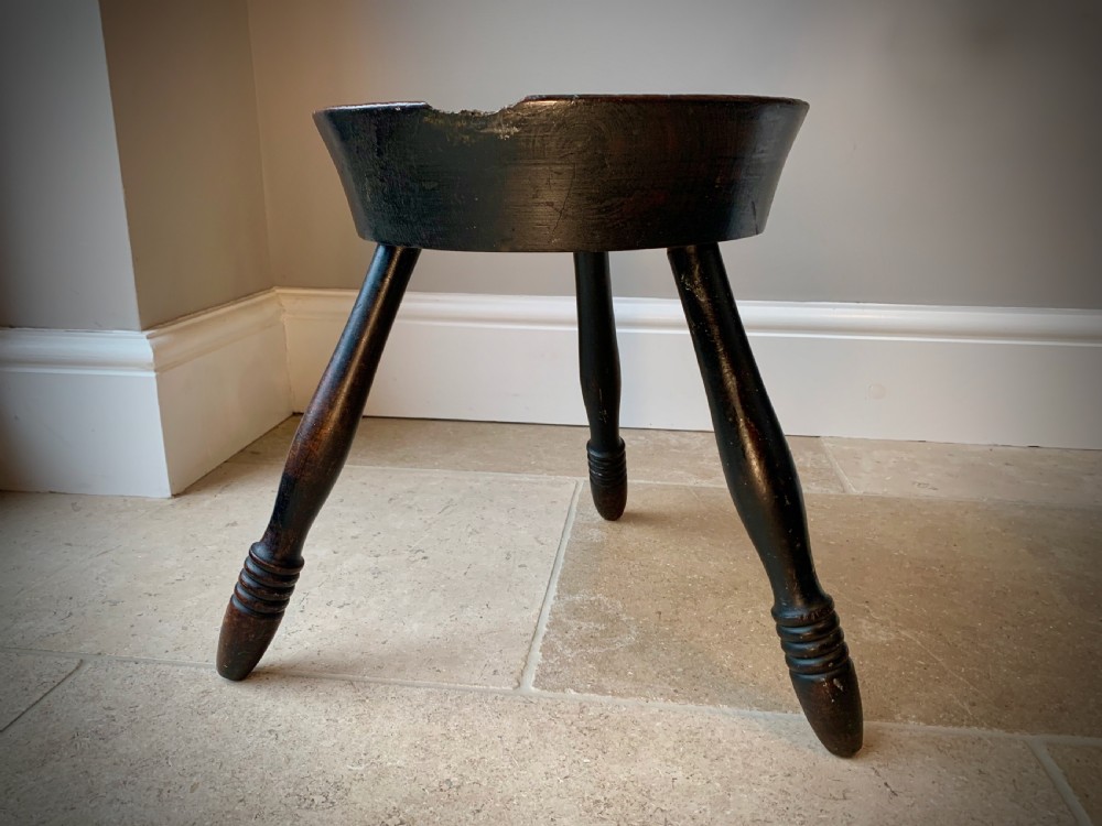 A 19th-century Scottish tripod stool crafted from dark brown wood with a circular seat featuring burnt pokerwork text and a Scottish thistle motif. View V