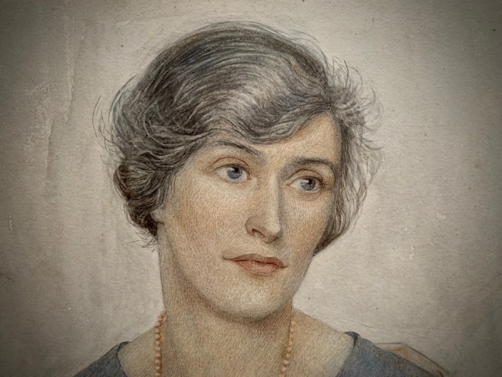 A framed 1928 watercolour painting of a young woman with short dark hair, wearing a blue jacket and shawl, set within a wide gold mount and ornate gilded frame. View III