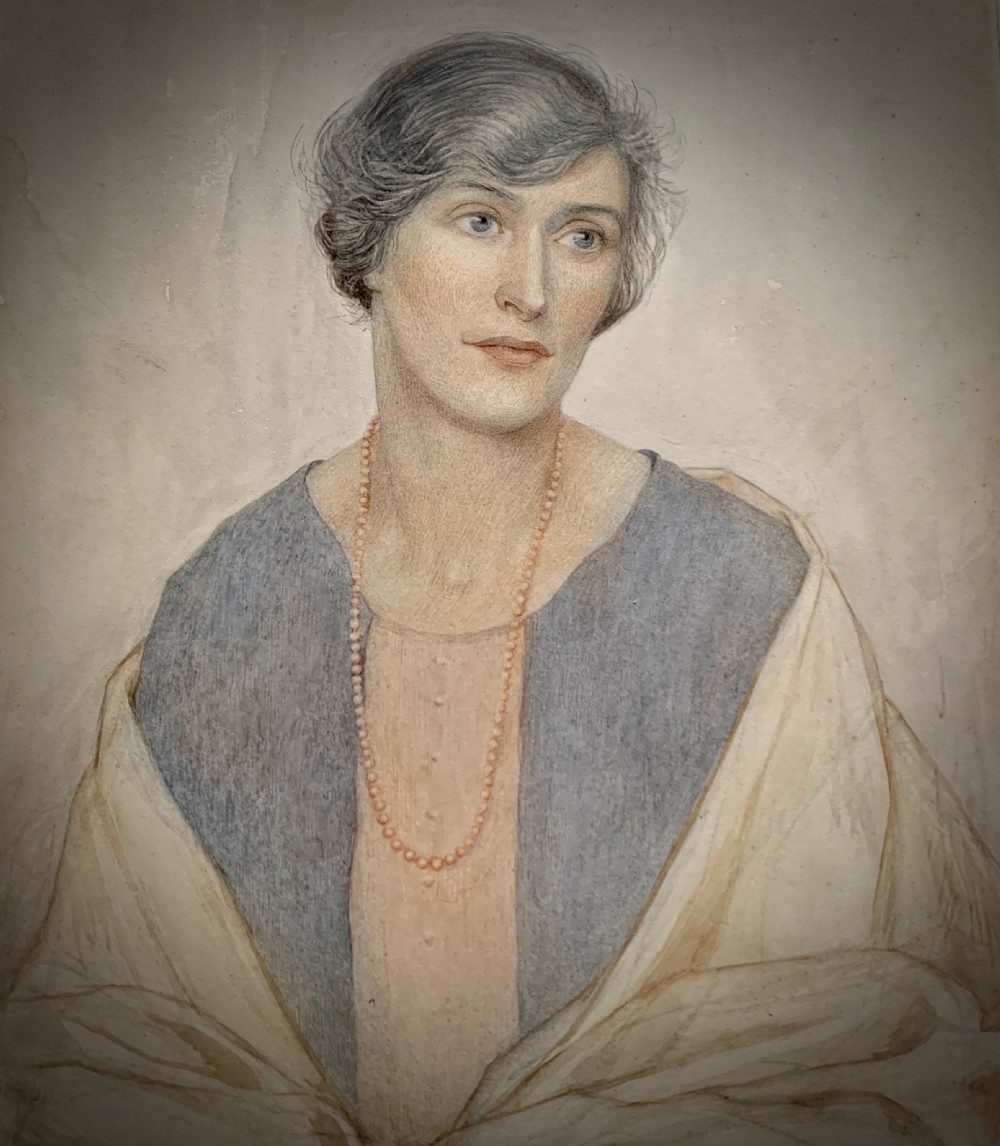 A framed 1928 watercolour painting of a young woman with short dark hair, wearing a blue jacket and shawl, set within a wide gold mount and ornate gilded frame. View IV