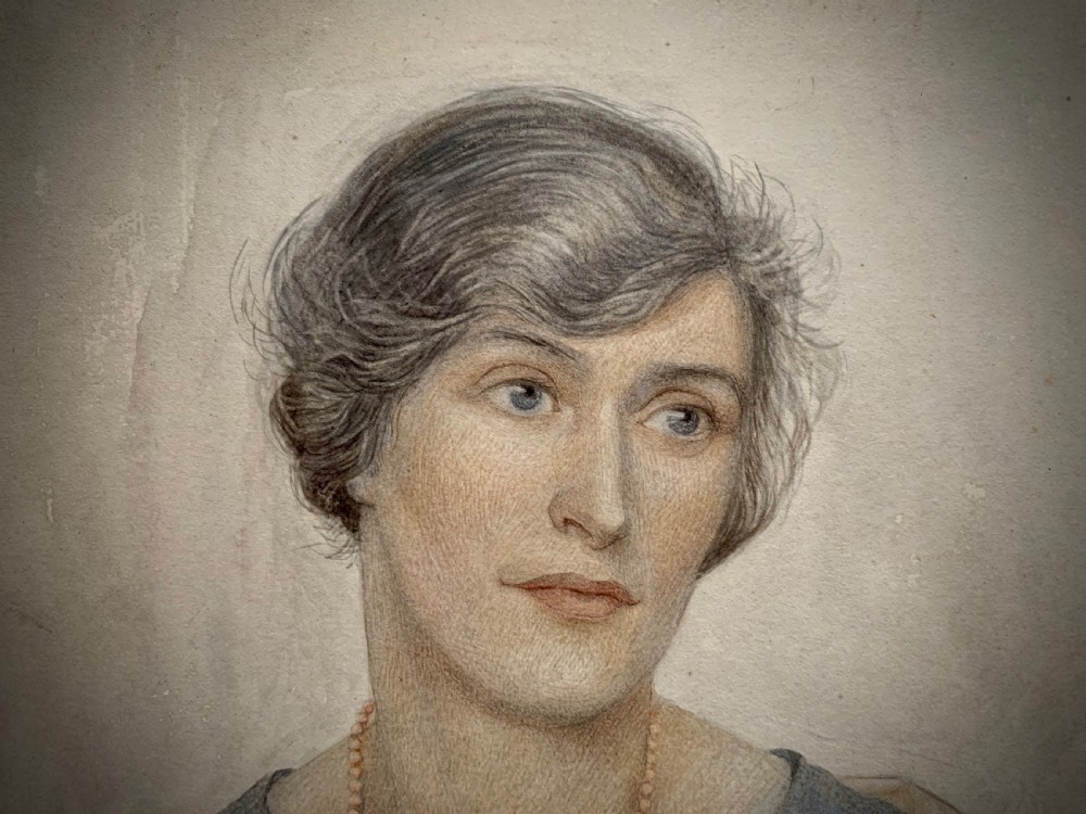 A framed 1928 watercolour painting of a young woman with short dark hair, wearing a blue jacket and shawl, set within a wide gold mount and ornate gilded frame. View VI