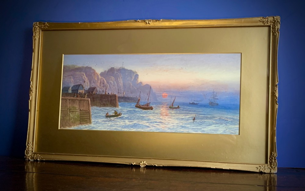 A horizontal Victorian watercolour painting depicting sailing boats in a coastal harbour at sunset, set within a wide gilded frame. View III