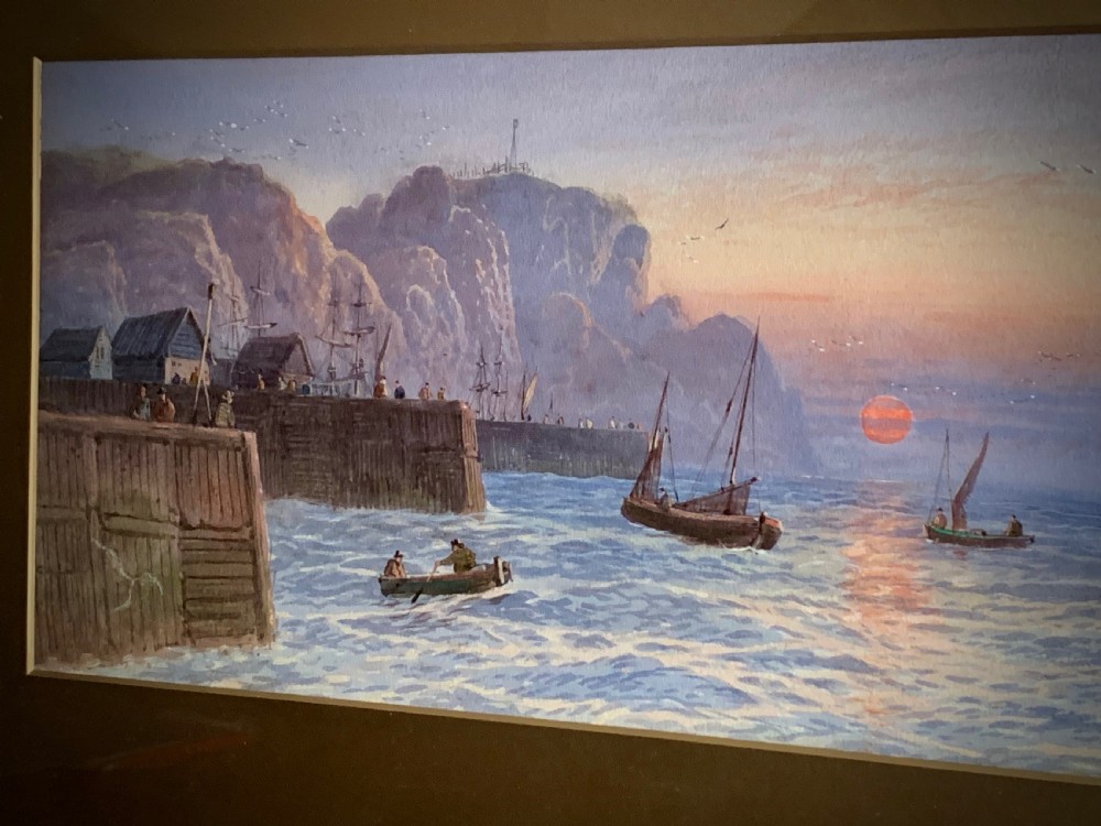 A horizontal Victorian watercolour painting depicting sailing boats in a coastal harbour at sunset, set within a wide gilded frame. View VII