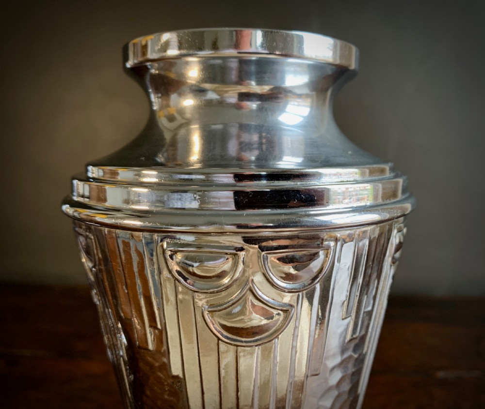 A pair of Art Deco chrome-plated metal vases with hammered lower bodies, geometric moulding near the rim, and circular stepped bases. View V