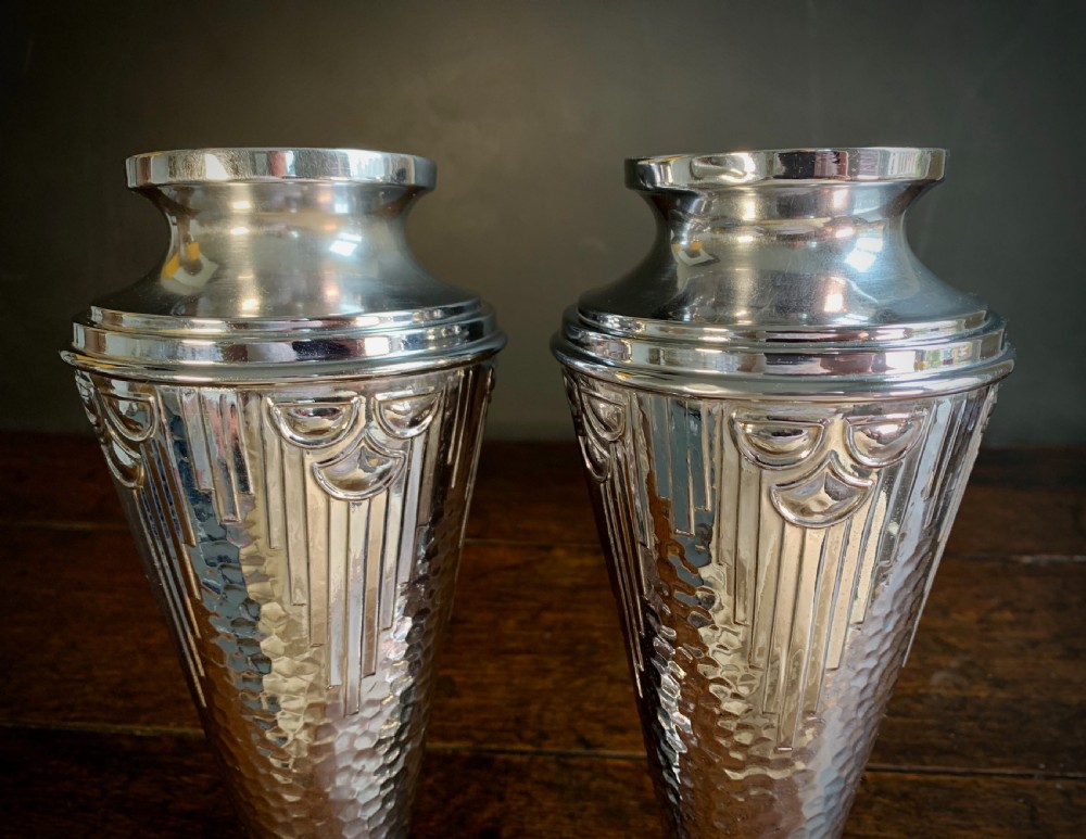 A pair of Art Deco chrome-plated metal vases with hammered lower bodies, geometric moulding near the rim, and circular stepped bases. View XVII