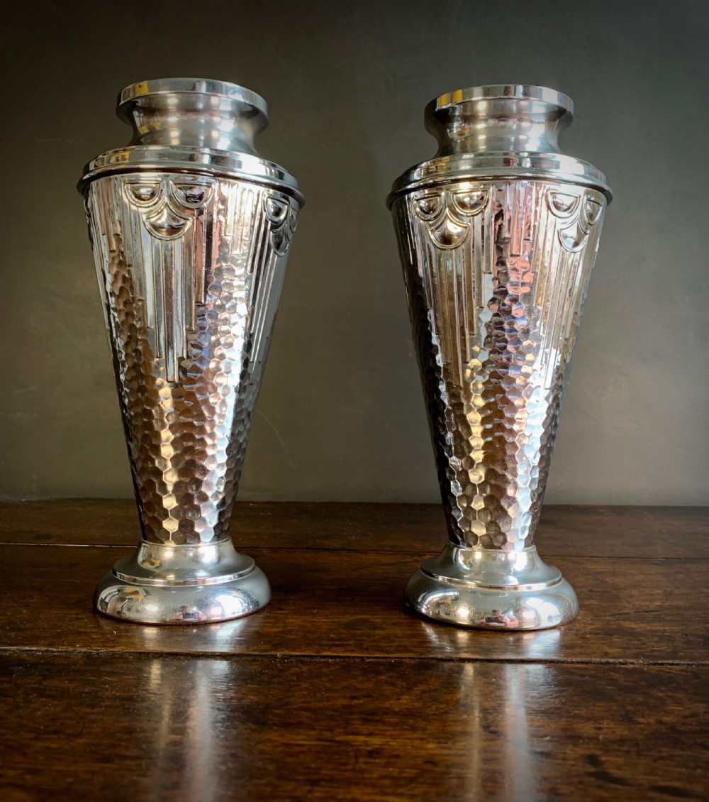 A pair of Art Deco chrome-plated metal vases with hammered lower bodies, geometric moulding near the rim, and circular stepped bases. View XXI