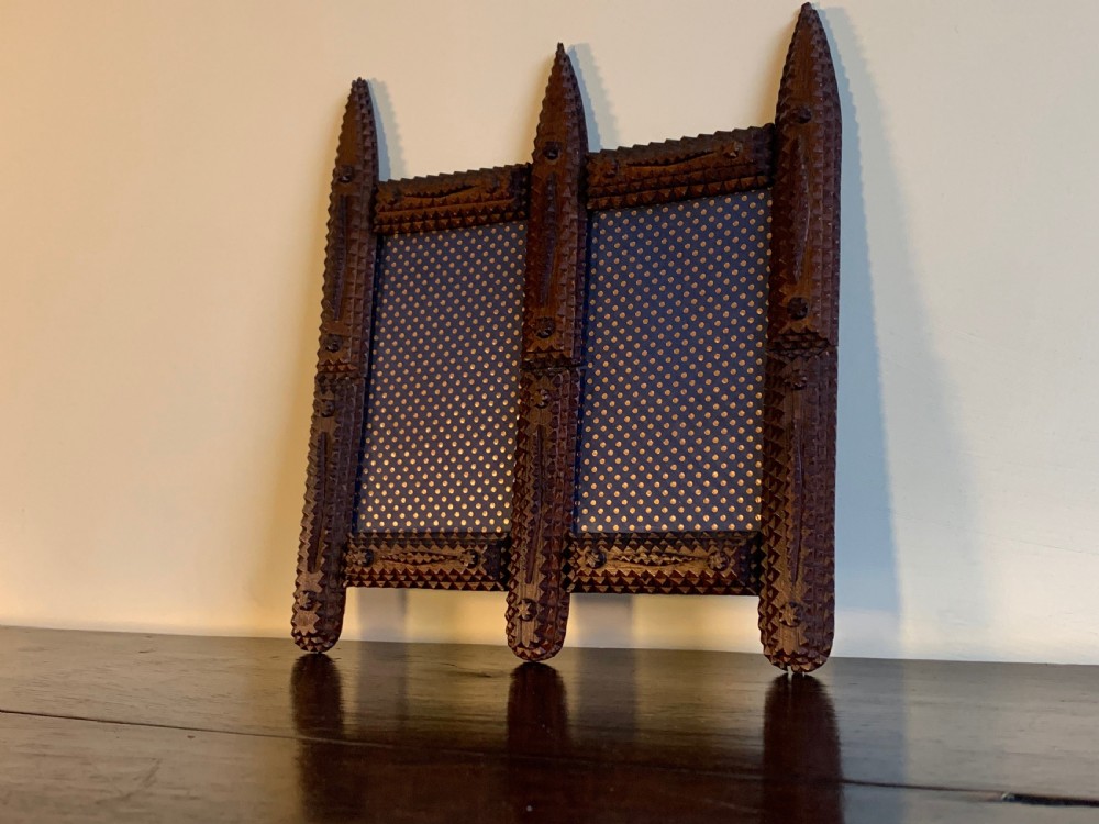 An antique tramp art double picture frame made of carved wood with layered notched geometric borders. View VIII