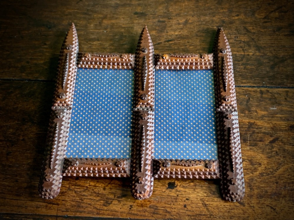 An antique tramp art double picture frame made of carved wood with layered notched geometric borders. View XIV