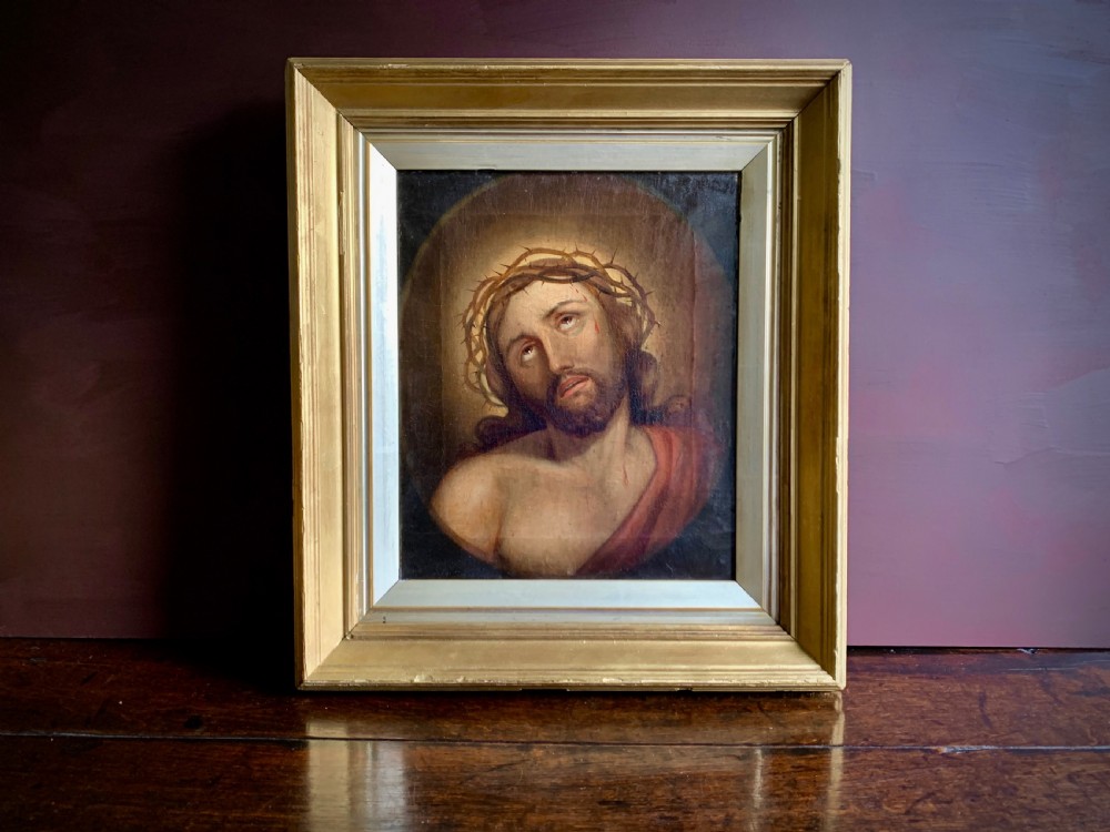 A 19th-century oil painting on canvas depicting Christ crowned with thorns set within a gold gilded wooden frame.