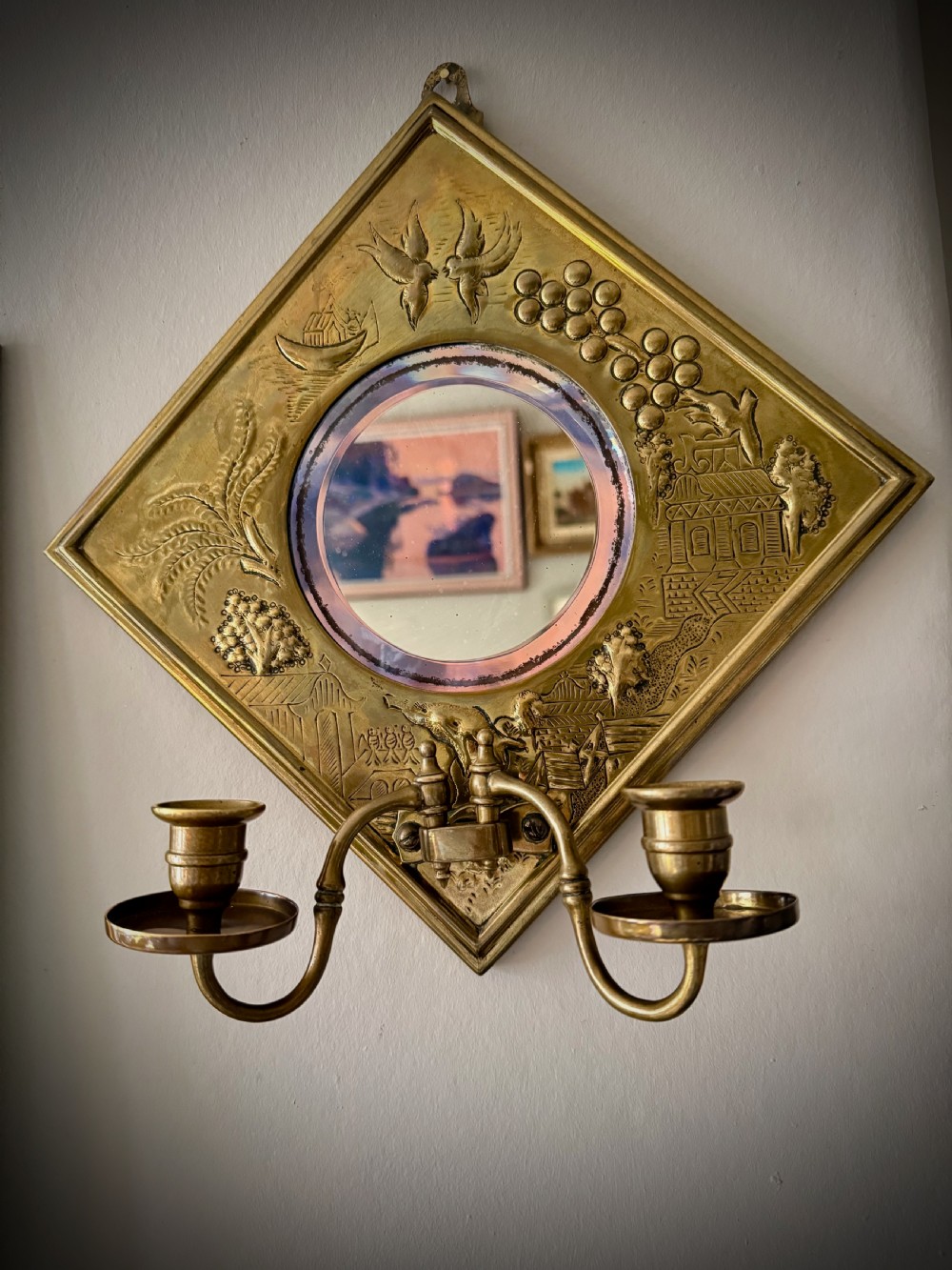 A pair of diamond-shaped embossed brass girandole wall mirrors featuring Chinoiserie scenes and twin candle branches. View III