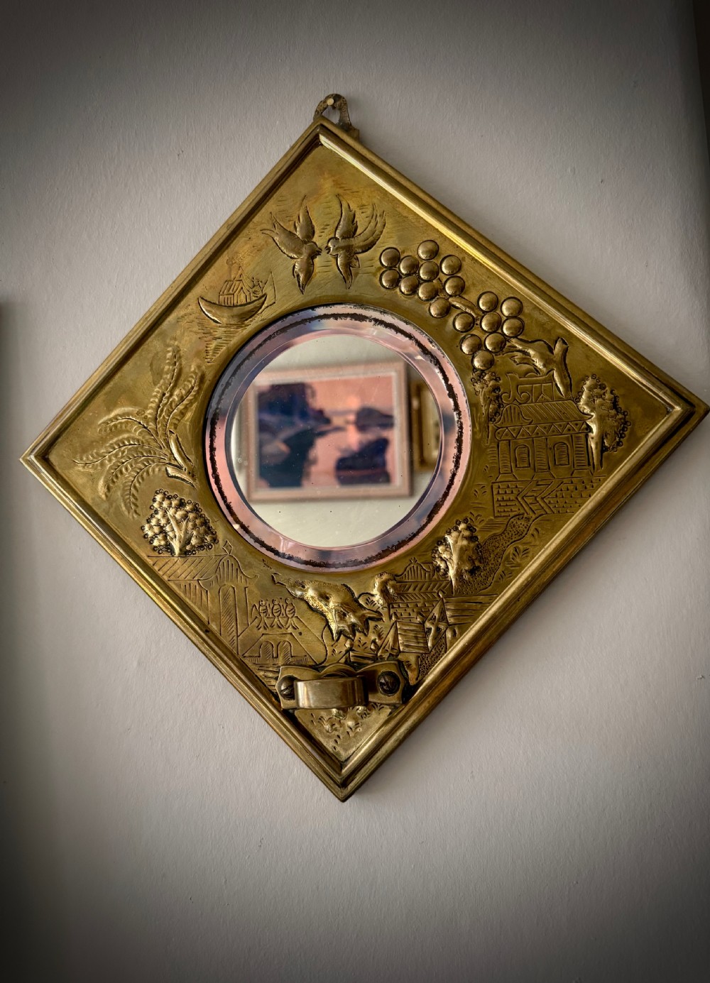 A pair of diamond-shaped embossed brass girandole wall mirrors featuring Chinoiserie scenes and twin candle branches. View IV