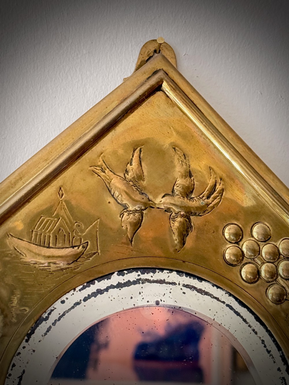 A pair of diamond-shaped embossed brass girandole wall mirrors featuring Chinoiserie scenes and twin candle branches. View VI