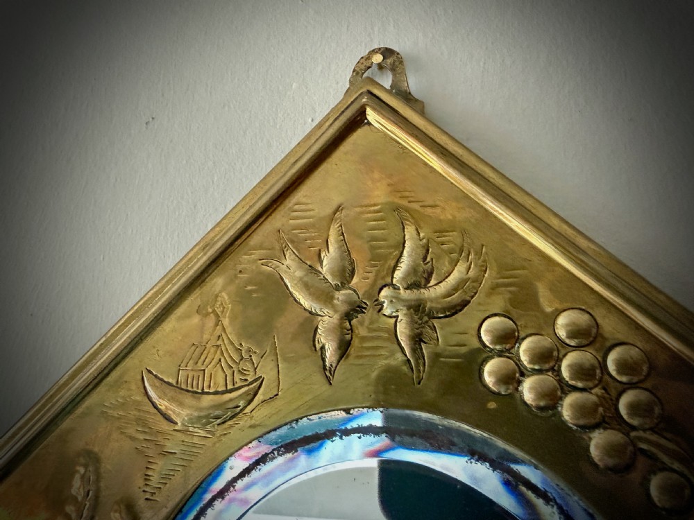 A pair of diamond-shaped embossed brass girandole wall mirrors featuring Chinoiserie scenes and twin candle branches. View VII