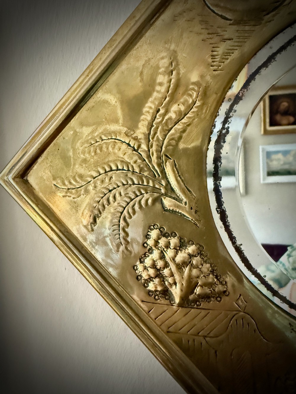 A pair of diamond-shaped embossed brass girandole wall mirrors featuring Chinoiserie scenes and twin candle branches. View VIII