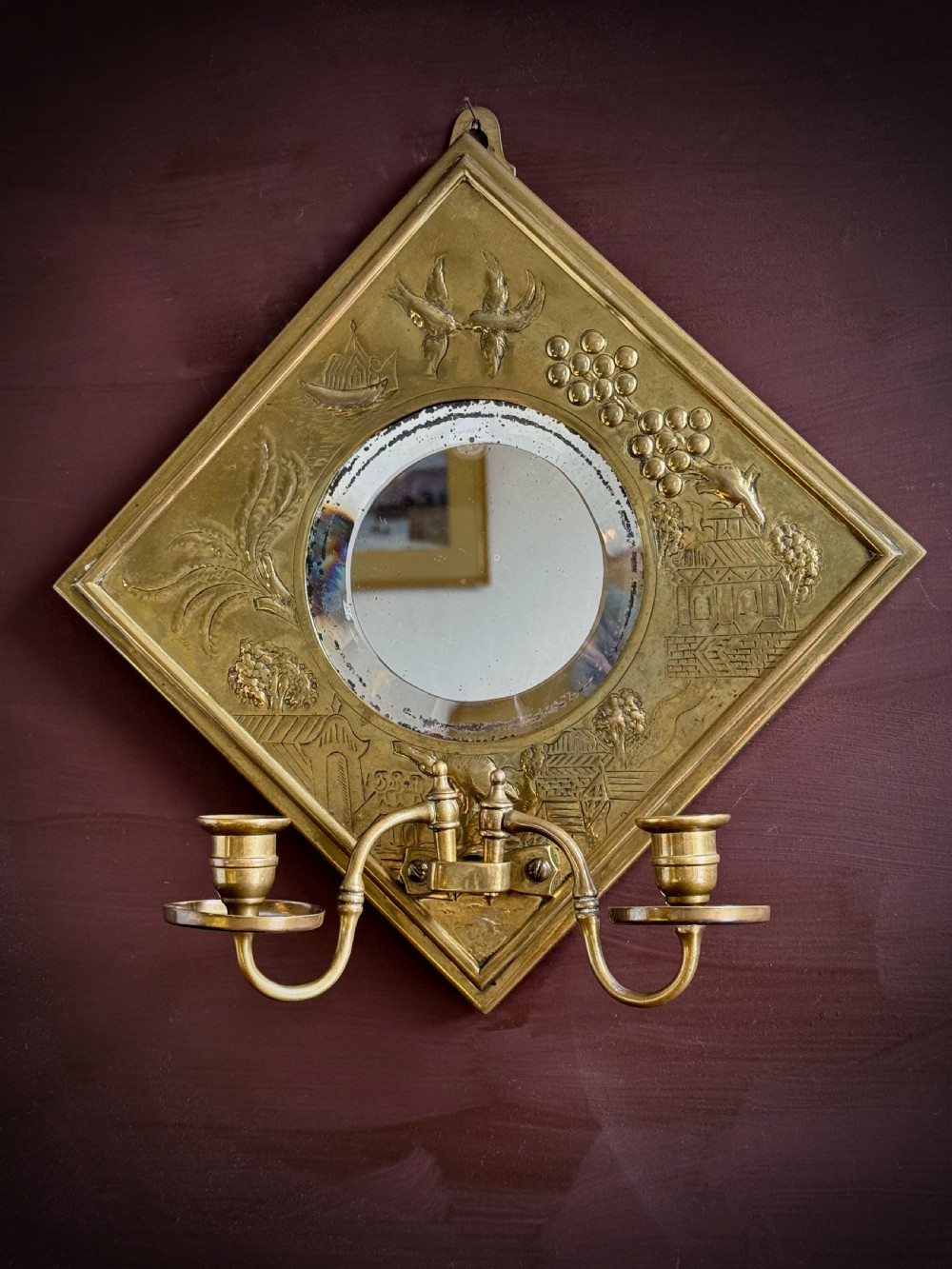 A pair of diamond-shaped embossed brass girandole wall mirrors featuring Chinoiserie scenes and twin candle branches. View XI