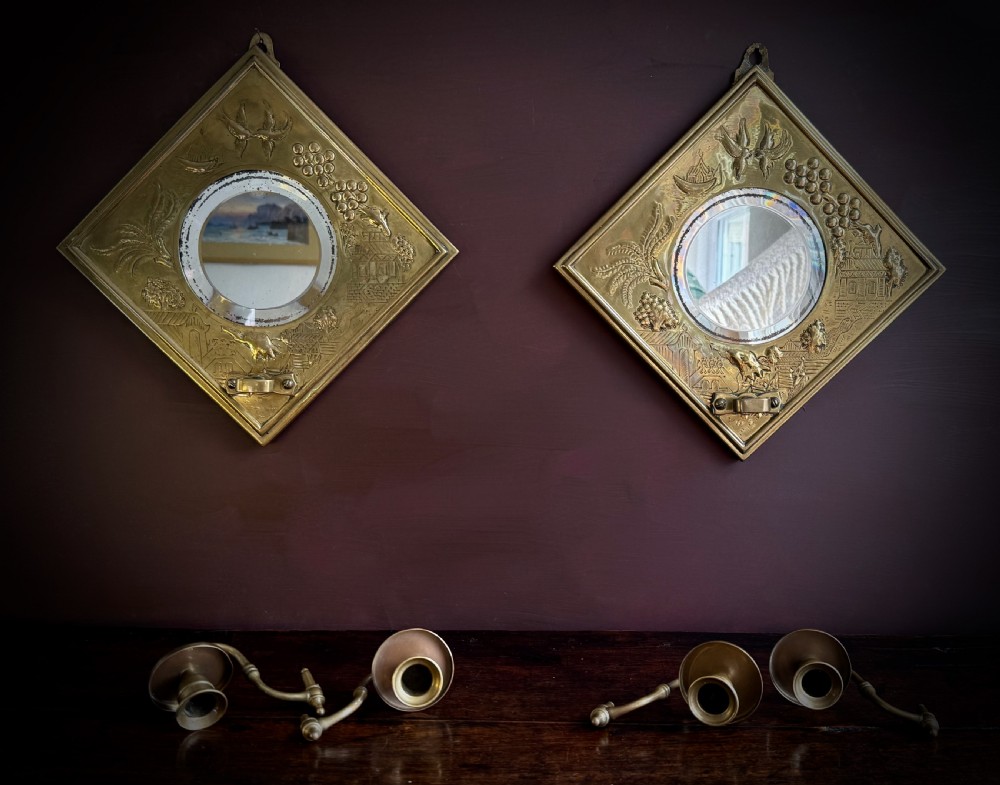 A pair of diamond-shaped embossed brass girandole wall mirrors featuring Chinoiserie scenes and twin candle branches. View XIII