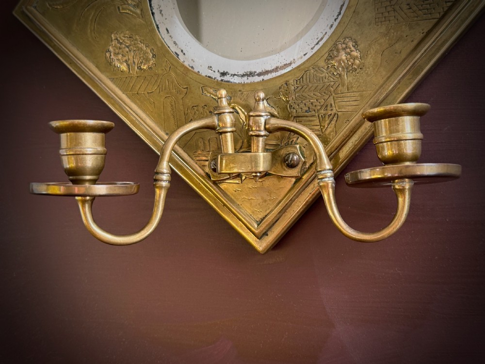 A pair of diamond-shaped embossed brass girandole wall mirrors featuring Chinoiserie scenes and twin candle branches. View XIV