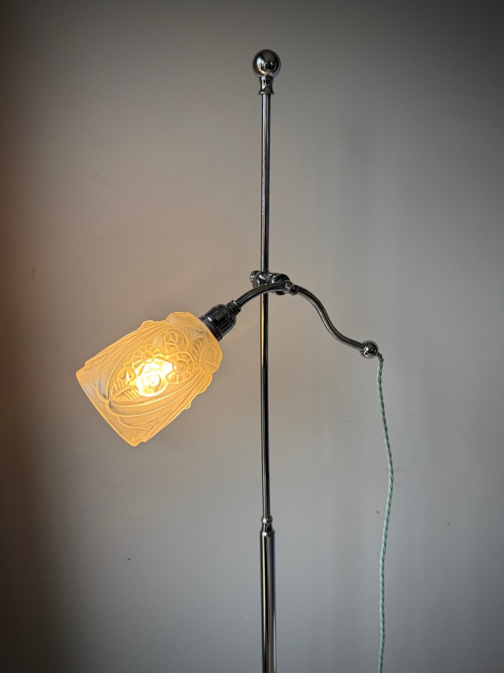 A slender 1920s Art Deco adjustable floor lamp crafted from polished chrome with an articulated neck and a lit frosted glass shade. View IV