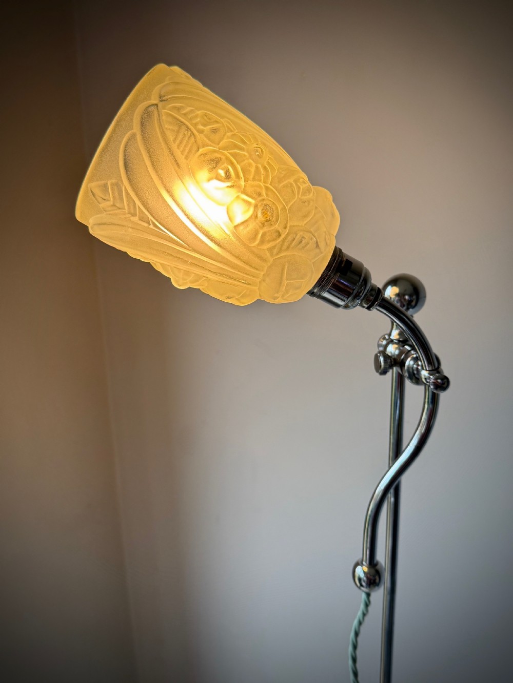 A slender 1920s Art Deco adjustable floor lamp crafted from polished chrome with an articulated neck and a lit frosted glass shade. View VII