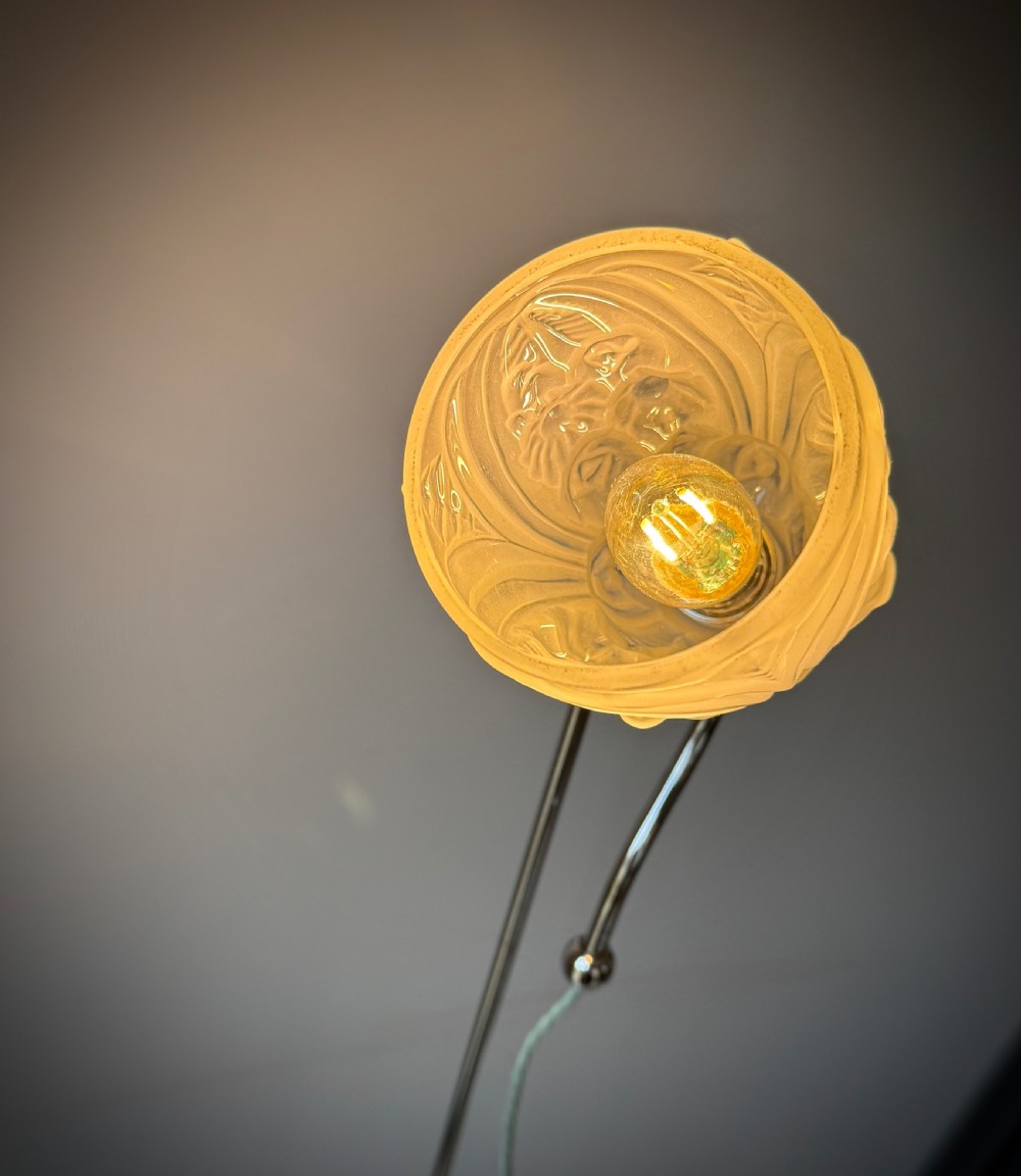 A slender 1920s Art Deco adjustable floor lamp crafted from polished chrome with an articulated neck and a lit frosted glass shade. View X