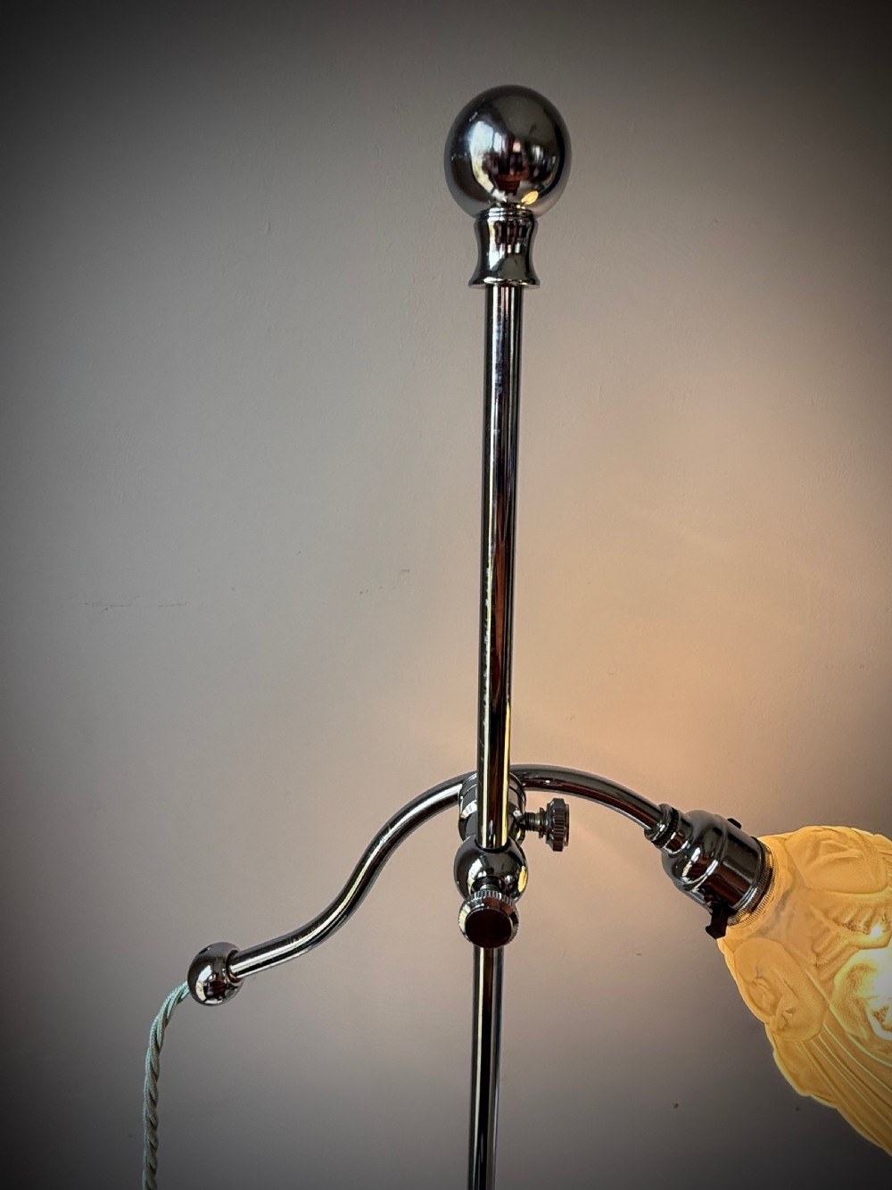 A slender 1920s Art Deco adjustable floor lamp crafted from polished chrome with an articulated neck and a lit frosted glass shade. View XVIII