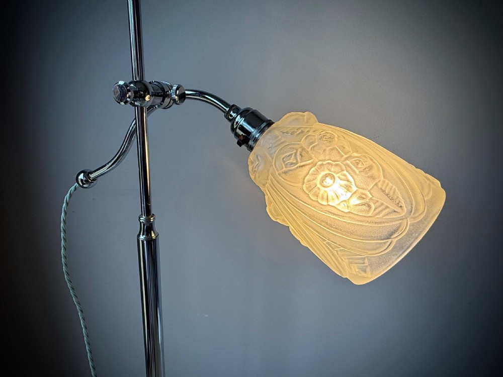 A slender 1920s Art Deco adjustable floor lamp crafted from polished chrome with an articulated neck and a lit frosted glass shade. View XXI