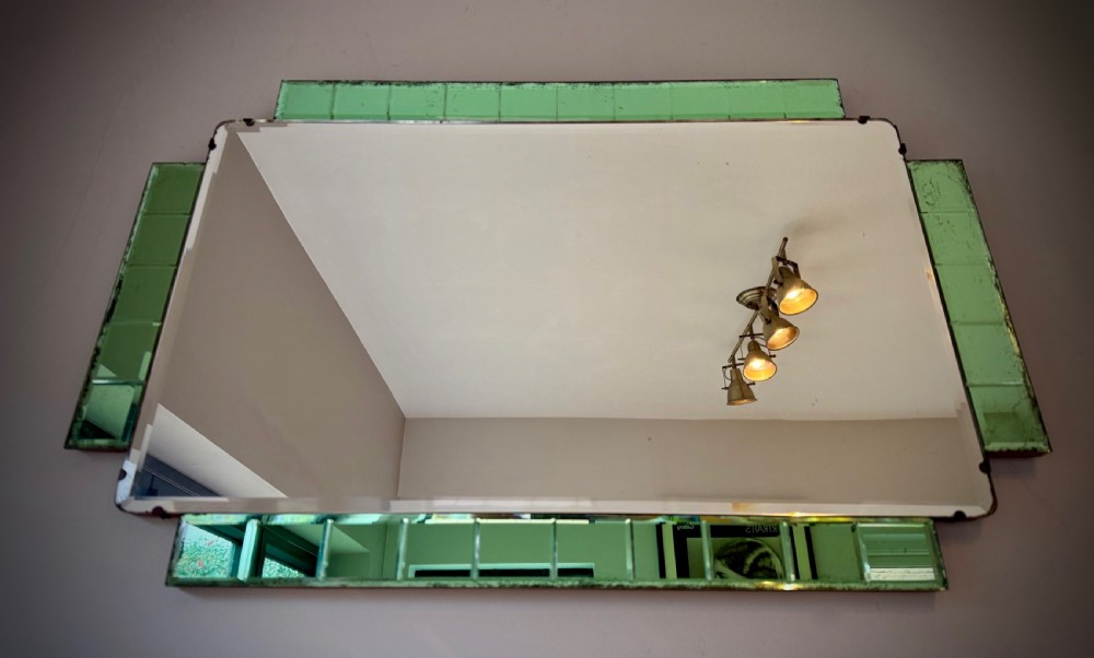 A rectangular Art Deco wall mirror featuring a central bevelled glass plate flanked by stepped emerald green tiled glass borders.