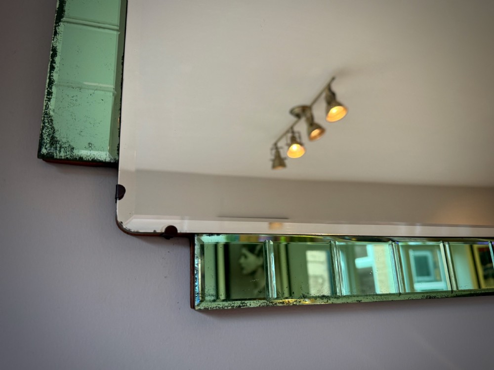A rectangular Art Deco wall mirror featuring a central bevelled glass plate flanked by stepped emerald green tiled glass borders. View VI