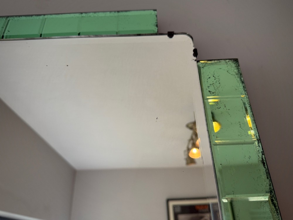 A rectangular Art Deco wall mirror featuring a central bevelled glass plate flanked by stepped emerald green tiled glass borders. View IX