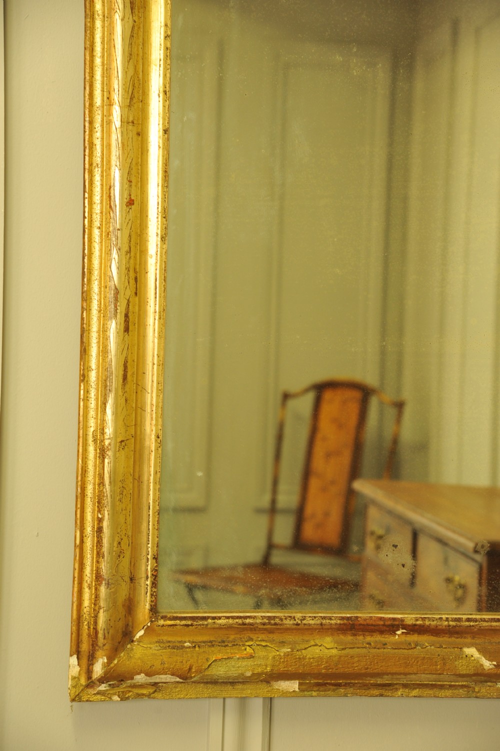A large 19th-century French wall mirror featuring a gilded gesso frame with rounded top corners and aged patina. View IV