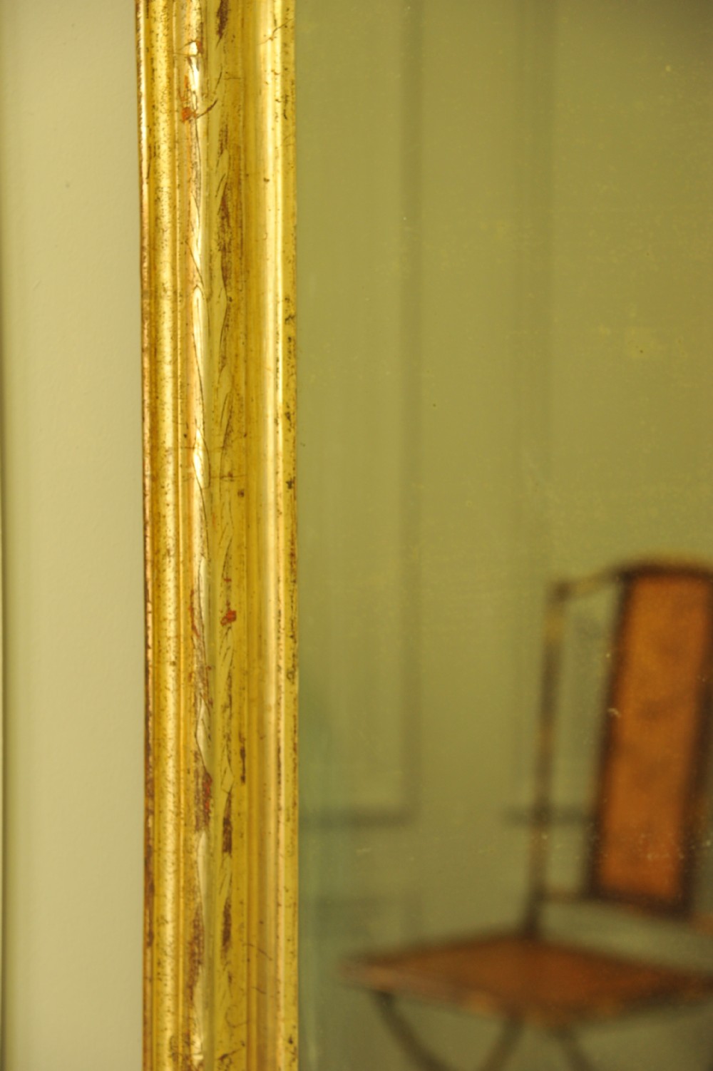 A large 19th-century French wall mirror featuring a gilded gesso frame with rounded top corners and aged patina. View VIII