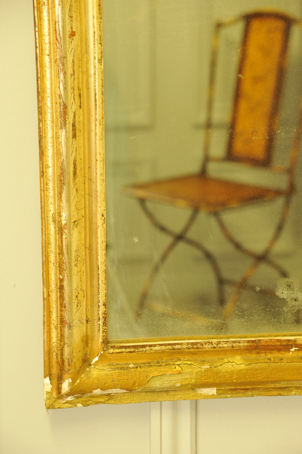 A large 19th-century French wall mirror featuring a gilded gesso frame with rounded top corners and aged patina. View IX
