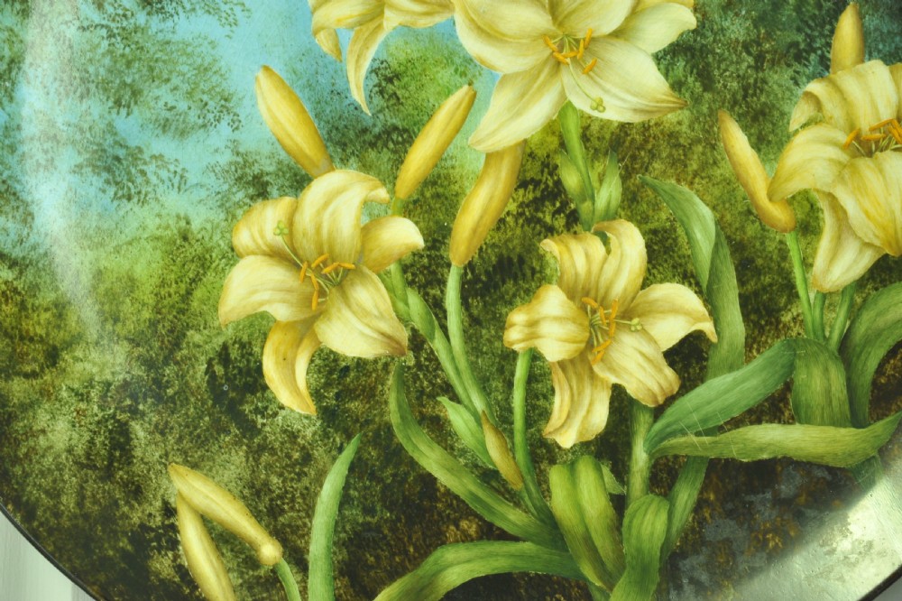 A circular hand-painted porcelain decorative plate displaying yellow lilies against foliage and a blue sky. View VI