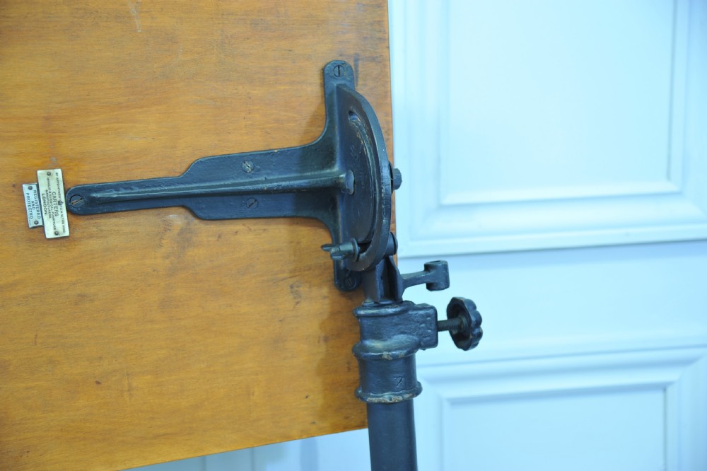 An antique adjustable oak top reading table mounted on a black cast iron pedestal base with castors. View VII