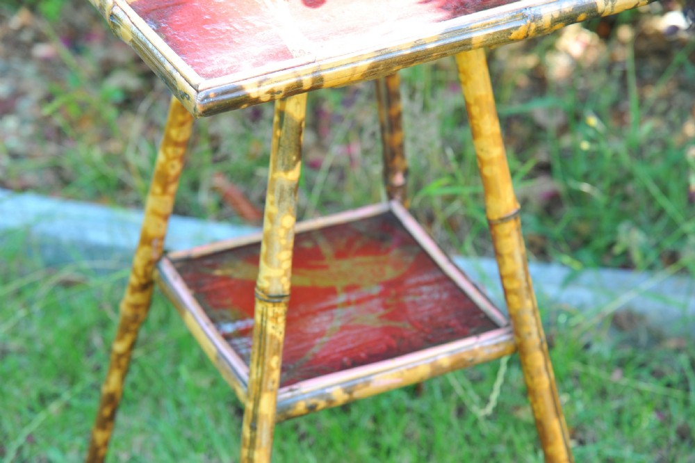 A two-tier bamboo side table featuring a square red lacquered top and lower shelf decorated with gilded bird and botanical motifs. View III