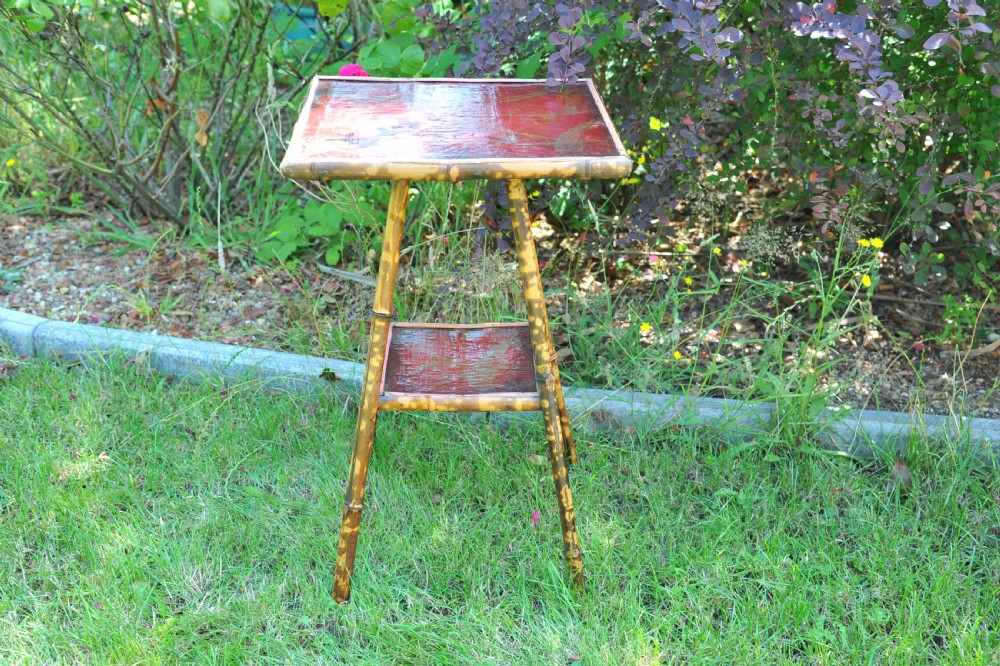 A two-tier bamboo side table featuring a square red lacquered top and lower shelf decorated with gilded bird and botanical motifs. View V
