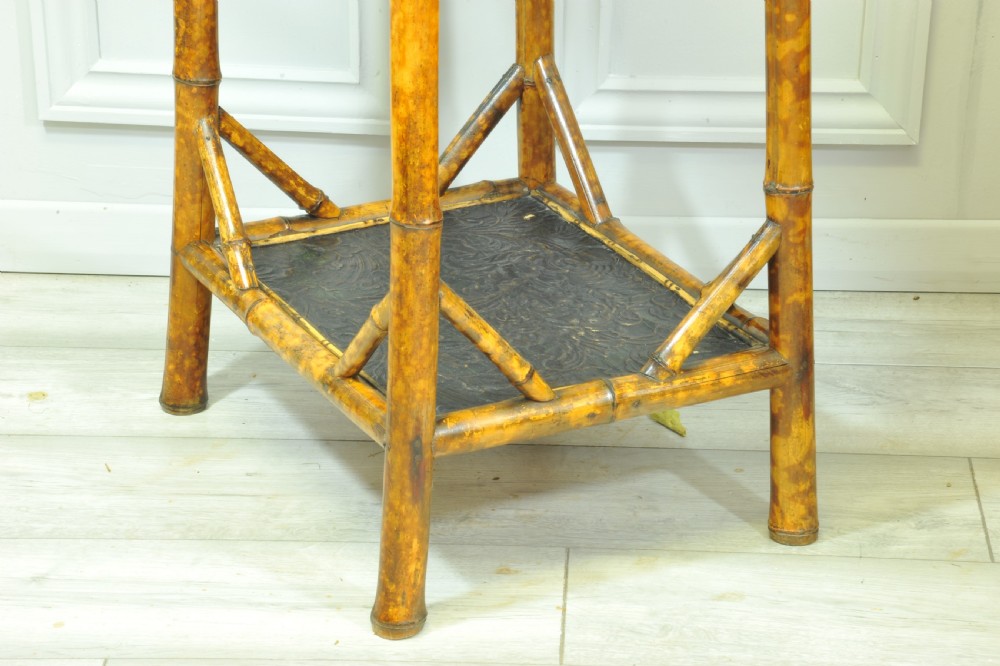 A late Victorian two-tier bamboo side table featuring a dark lacquered top panel decorated with botanical flora and birds. View VII