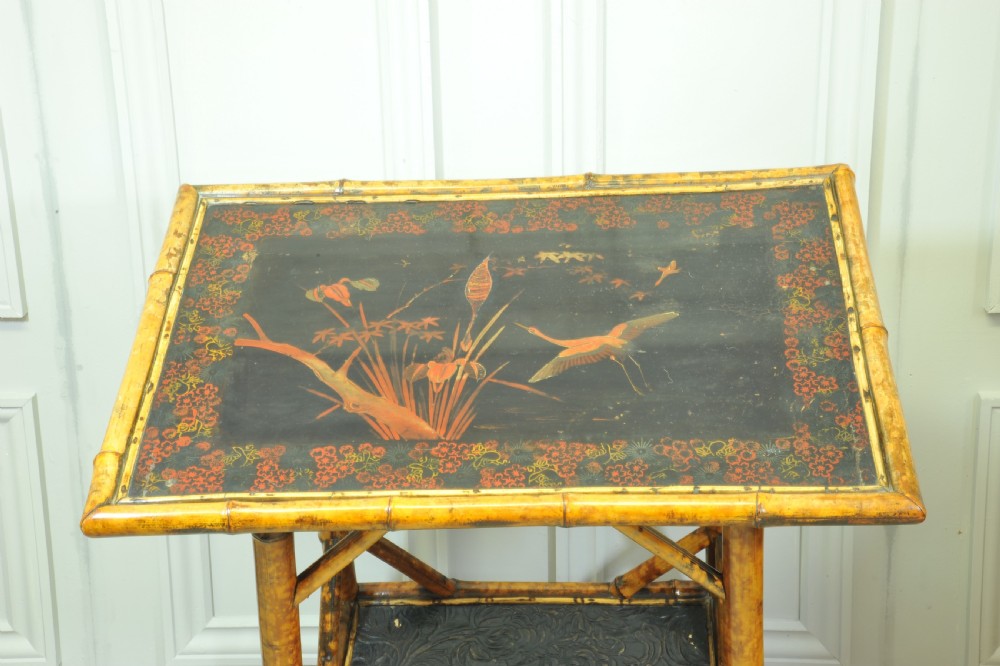 A late Victorian two-tier bamboo side table featuring a dark lacquered top panel decorated with botanical flora and birds. View VIII