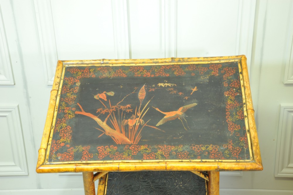 A late Victorian two-tier bamboo side table featuring a dark lacquered top panel decorated with botanical flora and birds. View IX